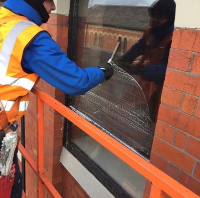 UCS none technical window cleaning A member of the Ultra Cleaning Service team cleaning a window with a squeegee - introducing Ultra Cleaning Service's window cleaning solutions